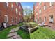 A quaint backyard featuring a garden bed and green space between two brick buildings at 1351 N Washington St # 15, Denver, CO 80203