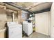 Basement utility area with a washer, dryer, storage rack, and exposed piping at 1351 N Washington St # 15, Denver, CO 80203