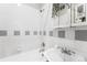 Bright bathroom features clean white tile with grey accents, updated fixtures, and a sink with plenty of counter space at 1351 N Washington St # 15, Denver, CO 80203