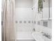 Bright bathroom features clean white tile with grey accents, updated fixtures, and a sink with plenty of counter space at 1351 N Washington St # 15, Denver, CO 80203