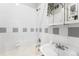 Classic bathroom featuring white tile, a combined bathtub and shower, and a hanging plant at 1351 N Washington St # 15, Denver, CO 80203