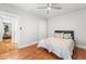Cozy bedroom with hardwood floors, a ceiling fan, white doors, and view into living area at 1351 N Washington St # 15, Denver, CO 80203