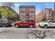 Apartment building exterior featuring red brick, white trim, and parked cars at 1351 N Washington St # 15, Denver, CO 80203