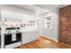Bright kitchen with white cabinets, tile backsplash, and hardwood floors at 1351 N Washington St # 15, Denver, CO 80203