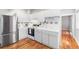 Bright kitchen with white cabinets, stainless steel refrigerator, and hardwood floors at 1351 N Washington St # 15, Denver, CO 80203