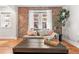 Well-lit living room with hardwood floors, exposed brick, and stylish decor at 1351 N Washington St # 15, Denver, CO 80203