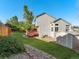 Large backyard with grass, shed, garden beds, and two-story home with back deck at 16212 Blueleaf Pl, Parker, CO 80134