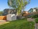 Landscaped backyard with grass, fence, and shed provides a serene outdoor space at 16212 Blueleaf Pl, Parker, CO 80134