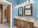 Bright bathroom features double vanity, framed mirrors, and custom closet with wooden shelves at 16212 Blueleaf Pl, Parker, CO 80134