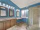 Modern bathroom featuring double sinks, vanity, tiled floors, and a glass-enclosed shower at 16212 Blueleaf Pl, Parker, CO 80134