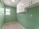 Bright laundry room with built-in white cabinets and neutral flooring at 16212 Blueleaf Pl, Parker, CO 80134