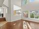 Bright living room with hardwood flooring, high ceilings, and views into the kitchen at 16212 Blueleaf Pl, Parker, CO 80134