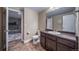 Bathroom with dark wood vanity, large mirror and view into adjacent bedroom at 5439 Innisbrook Loop, Elizabeth, CO 80107