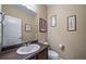 Cozy powder room showcases framed giraffe art above a dark wood vanity with a white sink at 5439 Innisbrook Loop, Elizabeth, CO 80107