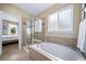 Bright bathroom featuring a soaking tub, separate shower and large window at 5439 Innisbrook Loop, Elizabeth, CO 80107