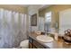 Cozy bathroom showcasing dark wood vanity, framed mirror, and patterned shower curtain at 5439 Innisbrook Loop, Elizabeth, CO 80107