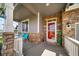 Front porch featuring stone accents, a red door and outdoor seating area at 5439 Innisbrook Loop, Elizabeth, CO 80107