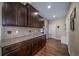 This open kitchen features dark cabinetry, granite countertops, and hardwood floors at 5439 Innisbrook Loop, Elizabeth, CO 80107