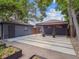 Backyard features a gray-tone building, a covered carport area, garden beds, and gravel landscaping at 3050 S Delaware St, Englewood, CO 80110