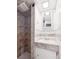 Small bathroom with stand-up shower, vintage vanity, and tile surround at 3050 S Delaware St, Englewood, CO 80110