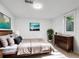 Sunlit bedroom boasts a large window, stylish dresser, and comfortable bed with throw blanket at 3050 S Delaware St, Englewood, CO 80110
