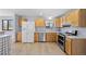 Bright, modern kitchen with stainless steel appliances and ample wood cabinetry at 7140 S Reed Ct, Littleton, CO 80128