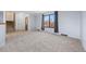 Spacious living room features new carpet, modern paint and an exterior view through the window at 7140 S Reed Ct, Littleton, CO 80128