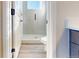 Modern bathroom with a glass-enclosed shower, neutral tile and flooring and white doors and trim at 11965 W 57Th Ln, Arvada, CO 80002