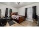 Bedroom with wood floors, natural light from windows, dark curtains, wooden bed frame and black shelves at 1882 S Stuart St, Denver, CO 80219