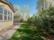 The lush backyard boasts mature trees, a manicured lawn, a concrete patio and a charming walkway to the home at 41 Garner Ln, Erie, CO 80516