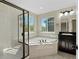 This large bathroom features a soaking tub, tiled shower, and double windows with lots of natural light at 41 Garner Ln, Erie, CO 80516