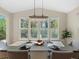 Bright dining area featuring modern chandelier, large windows, and elegant table setting at 41 Garner Ln, Erie, CO 80516