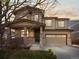Beautiful two-story home featuring a two-car garage, stone accents, and a welcoming front porch at sunset at 41 Garner Ln, Erie, CO 80516
