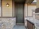 Elegant front door with stone accents and stylish exterior lighting at 41 Garner Ln, Erie, CO 80516