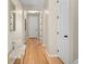 Bright hallway featuring hardwood floors, a white bench, and a view of a white door at 41 Garner Ln, Erie, CO 80516