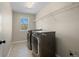 This well-lit laundry room features updated machines, tile flooring and a storage shelf for your laundry needs at 41 Garner Ln, Erie, CO 80516