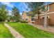 Exterior view of property featuring green grass, rock landscaping, and mature trees at 11705 W Stanford Ln, Morrison, CO 80465