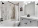 Bright bathroom featuring a shower and tub with decorative marble-style tile surround, and white vanity at 11705 W Stanford Ln, Morrison, CO 80465