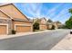 A row of townhomes with attached garages features neutral siding, and well-kept landscaping at 11705 W Stanford Ln, Morrison, CO 80465