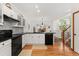 Open concept kitchen features black appliances, island sink, and hardwood floors at 11705 W Stanford Ln, Morrison, CO 80465
