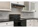 Contemporary black range with subway tile backsplash and white shaker cabinets at 11705 W Stanford Ln, Morrison, CO 80465