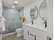 Modern bathroom featuring a dual sink vanity and a glass-enclosed shower with gray tiles at 8217 W 71St Pl, Arvada, CO 80004