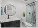 Modern bathroom featuring a stylish vanity, toilet, and glass-enclosed shower with elegant marble tiling at 8217 W 71St Pl, Arvada, CO 80004