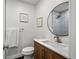 Stylish powder room with a wood vanity, modern fixtures, and decorative mirror at 8217 W 71St Pl, Arvada, CO 80004