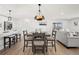 Bright open-concept dining area with modern chandelier and seating for four at 8217 W 71St Pl, Arvada, CO 80004