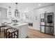 Modern kitchen with white cabinets, stainless steel appliances, and a breakfast bar at 8217 W 71St Pl, Arvada, CO 80004