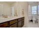 Bathroom with a double sink vanity with a marble countertop, chrome fixtures, and a shower with white tiling at 8760 Ginkgo Loop, Parker, CO 80134