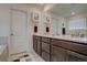 Bathroom features double sinks, modern fixtures, vanity and mirror with a door leading to the toilet area at 8760 Ginkgo Loop, Parker, CO 80134