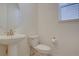 Small powder bath features a pedestal sink, rounded mirror, and a window for natural light at 8760 Ginkgo Loop, Parker, CO 80134