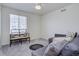 A relaxing bedroom with a large window, neutral walls, soft carpeting, and a gray sofa that offers additional seating at 8760 Ginkgo Loop, Parker, CO 80134